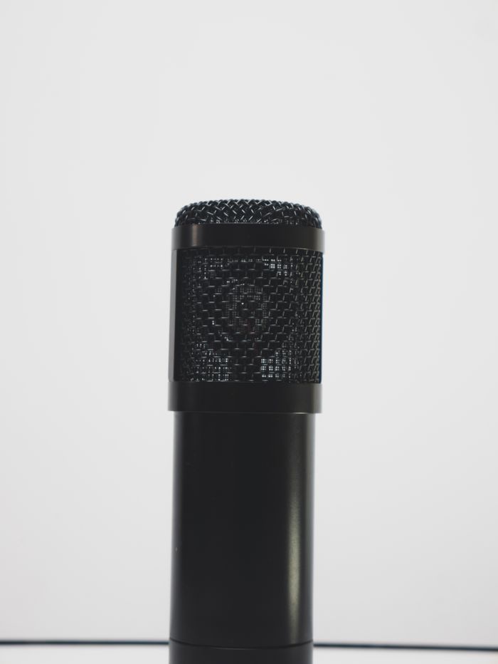 who-we-are Gros plan d’un microphone noir sur fond blanc, idéal pour des thèmes liés à l’enregistrement audio.